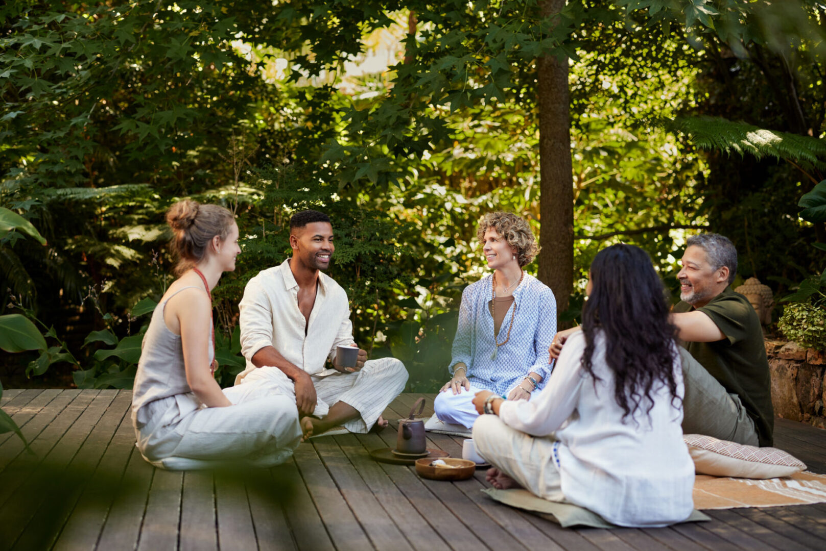 Group relaxing outdoors on wooden deck.